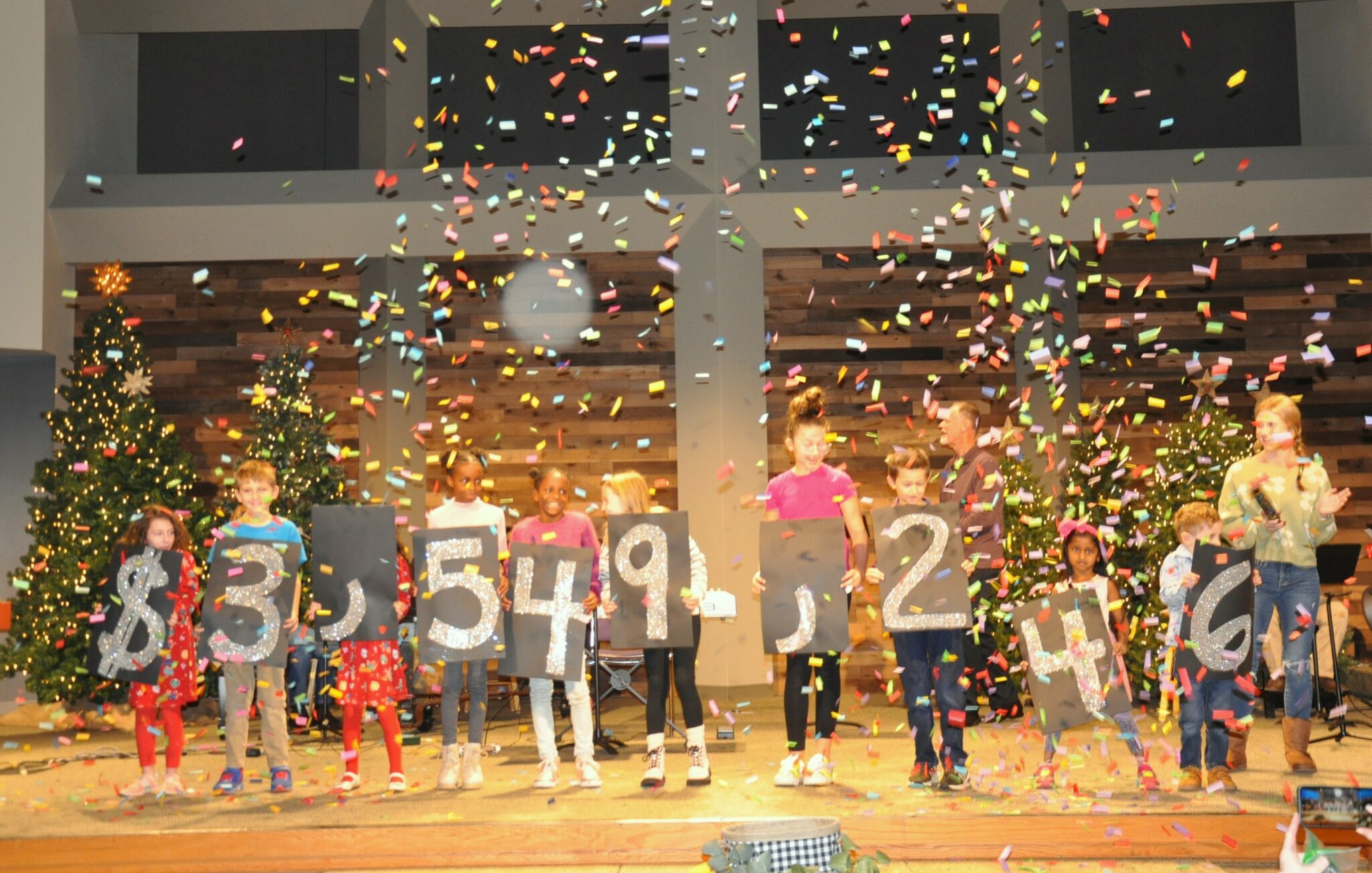 kids at church hold number signs while confetti falls